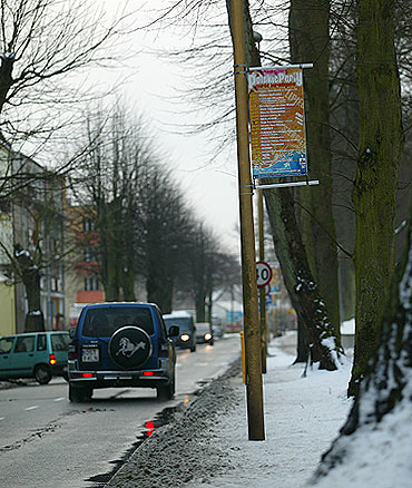 Na brudnych latarniach wiszą plakaty z wakacji