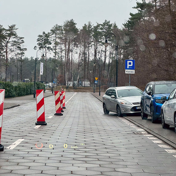 Zaparkował tak, iż zablokował pas ruchu. Kierowcy przeciskają się między pachołkami na ulicy Zdrojowej