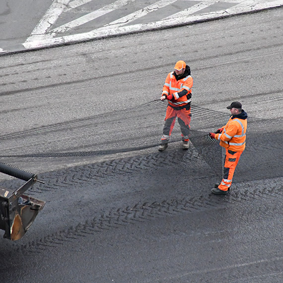 Siatka pod asfaltem na ulicy 11 Listopada. To nie gadżet, tylko technologia, która ma opóźniać pękanie nawierzchni