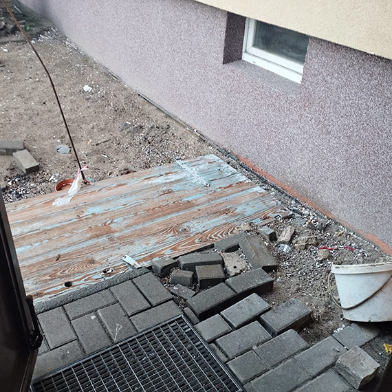 Mieszkanka czeka od miesięcy. Rozkopane wejście do budynku i prowizoryczna kładka zamiast chodnika